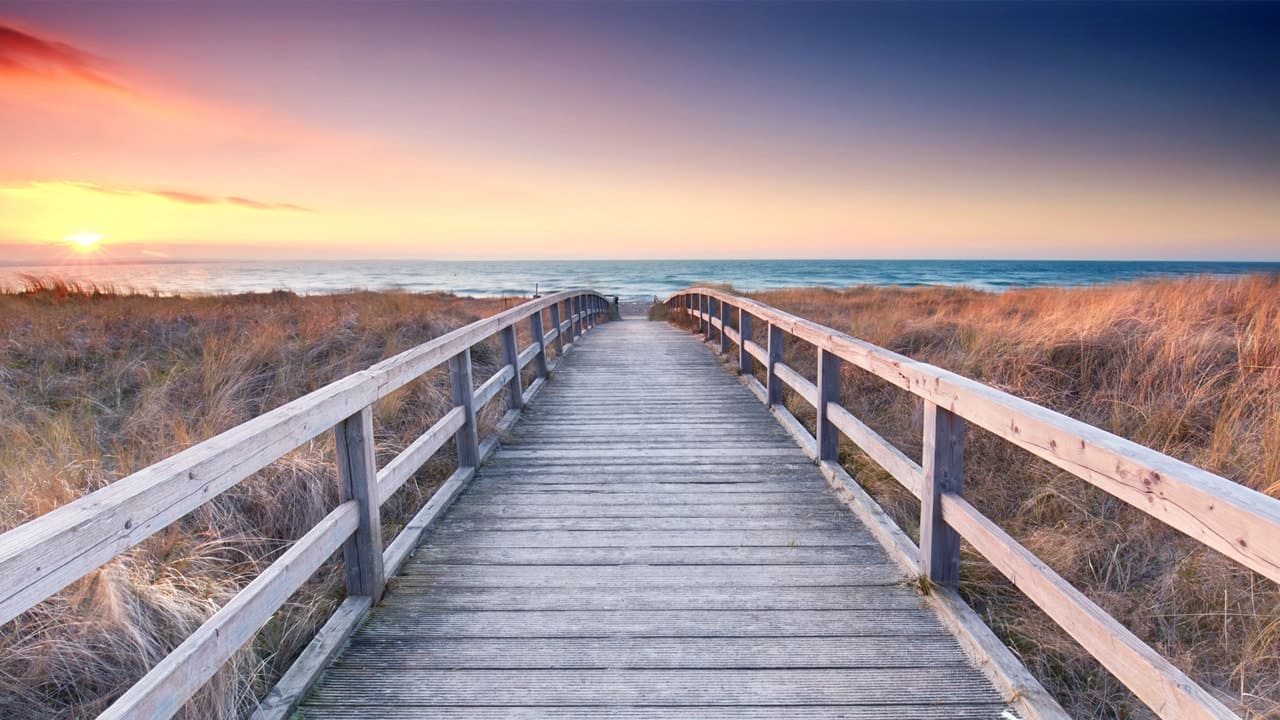 Badebrücke führt zum Strand, Sonnenuntergang, Landschaft Dünen. 